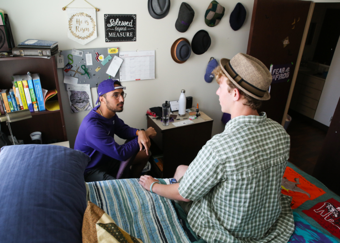 two male students talking in a bedroom