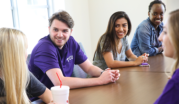 tcu-housing students talking at a table