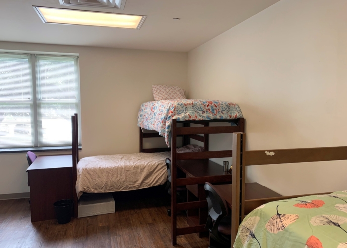 three lofted beds with desk and chairs